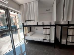 2 literas en una habitación con ventana en Saranda Boutique Hostel, en Sarandë