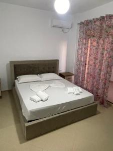 1 dormitorio con 1 cama con 2 toallas en Elision Apartments, en Sarandë