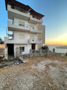 un edificio en una colina con el océano en el fondo en Elision Apartments, en Sarandë