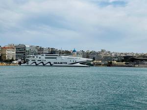 un grand bateau dans l'eau avec une ville en arrière-plan dans l'établissement Royal Blue Grand Suite No 2, au Pirée