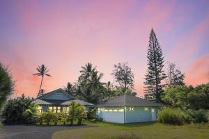 ein Haus mit einer weißen Garage und Palmen in der Unterkunft Gorgeous Renovated 1937 Plantation Style Beach House 50 Steps to the Center of the Beach home in Kailua