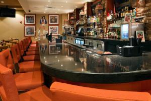 un bar con posti arancioni in un ristorante di Holiday Inn Baton Rouge College Drive I-10, an IHG Hotel a Baton Rouge