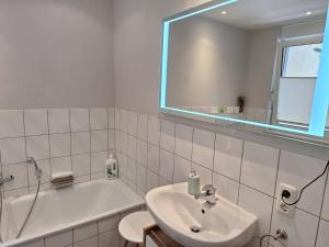 a bathroom with a sink and a tub and a mirror at Villa Feyen in Trier in Trier