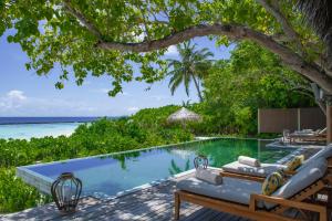 una piscina con sillas y vistas al océano en Baros Maldives, en Male