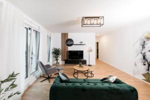 uma sala de estar com um sofá verde e uma televisão em koCASA-Apartments 01, City-Center Böblingen, Stellplatz, Balkon, Waipu-Tv em Böblingen