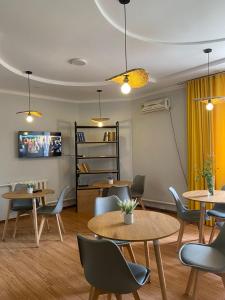 a waiting room with tables and chairs and a tv at Hostel Saruu in Bishkek