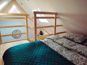 een slaapkamer met een groen bed en een ladder bij Domek Pocieszna Podkowa in Rabka-Zdroj