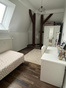 a white living room with a bed and a table at 4 Zimmer Design Atelier Wohnung in Goslar