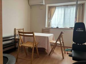 une chambre avec une table, des chaises et une fenêtre dans l'établissement Guest House Harukawa, à Osaka