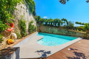 uma piscina num quintal com uma parede de retenção em Hotel Villa Sermolli em Borgo a Buggiano