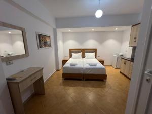 1 dormitorio con 2 camas y cocina. en Anna Rooms, en Sarandë