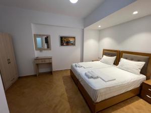 1 dormitorio con 1 cama grande con sábanas blancas en Anna Rooms, en Sarandë