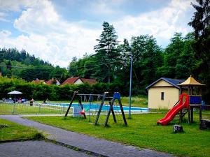 einen Park mit Spielplatz mit Rutsche und Pool in der Unterkunft Hotel Bazant in Karlsbad