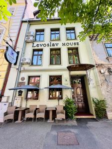 a building with a table and chairs in front of it at Villa & Restaurant Levoslav House in Sibiu