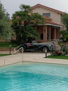 une voiture vintage est garée devant une maison dans l'établissement Villa Marianna, à Alghero