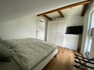 um quarto com uma cama e uma televisão de ecrã plano em Sahr Appartements em Kulmbach