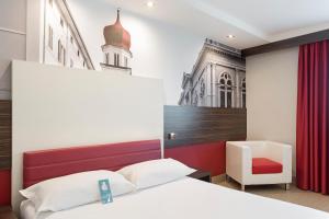 Tempat tidur dalam kamar di B&B Hotel Trento