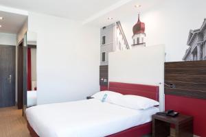 Tempat tidur dalam kamar di B&B Hotel Trento