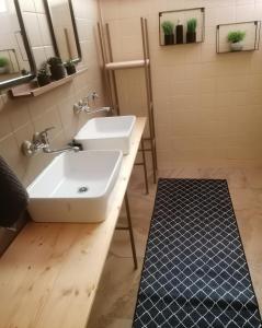 a bathroom with two sinks and two mirrors at Apartman ClaRa in Štúrovo