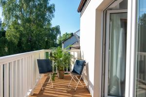 zwei Stühle auf einer Terrasse neben einem Haus in der Unterkunft Leo House in Gdynia