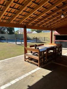 une table et des bancs en bois sous une pergola en bois dans l'établissement Casa Arguello, à Córdoba