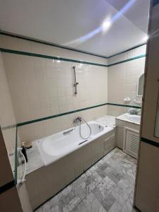 La salle de bains est pourvue d'une baignoire et d'un lavabo. dans l'établissement Appartement slim centre sousse, à Sousse