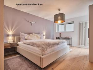 シュルッフゼーにあるVilla Sunside Schluchsee - Appartements Modern Style & Superiorのベッドルーム(白いベッド1台、ペンダントライト付)