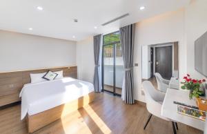 een slaapkamer met een groot bed, een bureau en stoelen bij Green LP Hotel & Apartment in Vung Tau