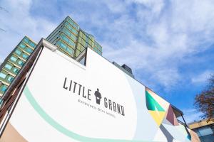 um grande sinal branco com um edifício ao fundo em Little Grand em Eindhoven