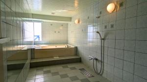 a bathroom with a tub and a shower at 瀬戸内リゾートホテル in Matsuyama