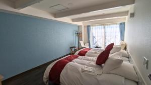 a bedroom with two beds and a window at 瀬戸内リゾートホテル in Matsuyama