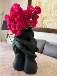 una estatua de una persona sosteniendo un ramo de flores rosas en River House, en Yaremche