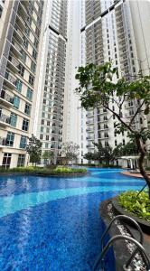 a large blue pool in front of tall buildings at Apt Puri Orchard at puri in Jakarta