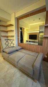 a bedroom with a large bed and a large mirror at Apt Puri Orchard at puri in Jakarta