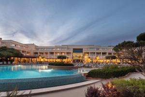 un complexe avec une piscine et un bâtiment dans l'établissement Onyria Quinta da Marinha Hotel, à Cascais