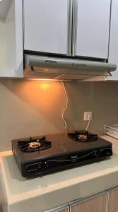 a stove top oven sitting on top of a kitchen counter at Apt Puri Orchard at puri in Jakarta