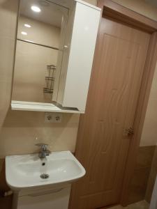 a bathroom with a sink and a mirror and a door at Elos-Home in Tbilisi City