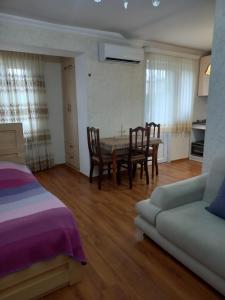 a living room with a table and chairs and a couch at Elos-Home in Tbilisi City