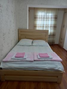 a bedroom with a bed with two pink towels on it at Elos-Home in Tbilisi City