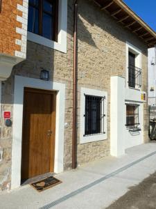 サンティリャーナ・デル・マルにあるCasa los Patos en Santillana Del Marの木の扉が横に建つ建物