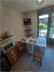 a kitchen with a desk and a table with a microwave at Tout compris 5pers à Bg St Maurice therighthouse in Bourg-Saint-Maurice