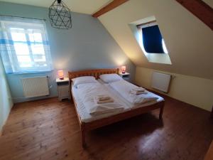 een slaapkamer met een bed met witte lakens en 2 lampen bij Penzion U Lucerny in Jindrichuv Hradec