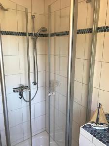 La salle de bains est pourvue d'une douche avec une porte en verre. dans l'établissement Kompassrose, à Prerow