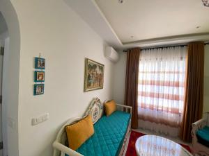 Marsa-Sidi Bousaid Cosy Authentic Apartment في المرسى: غرفة بها أريكة زرقاء ونافذة