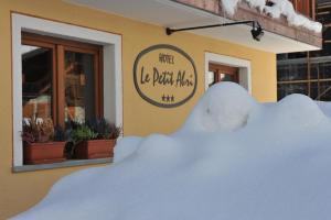 a pile of snow in front of a building at Hotel Le Petit Abri in Champoluc