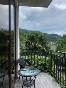 d'une terrasse avec une table et des chaises sur un balcon. dans l'établissement Horizon Hills - ჰორიზონ ჰილს, à Kvariati