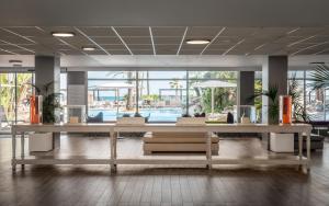 un hall avec des tables et des chaises ainsi qu'une piscine dans l'établissement Estival Centurión Playa, à Cambrils