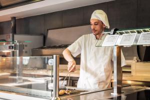 - un chef debout dans une cuisine préparant des plats dans l'établissement Estival Centurión Playa, à Cambrils