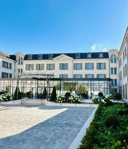 um grande edifício com um pátio em frente em La Licorne Hotel & Spa Troyes MGallery em Troyes