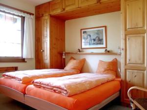 a bedroom with two beds with orange cushions at Cosy Apartment in Bellwald 68 m² Mountain View in Bellwald